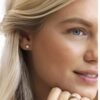 orhangen_ring_titan_blomdahl_7330981521588_7330981571781_15-12166-01_31-120166-1701.jpg Close-up of a woman wearing elegant diamond stud earrings, showcasing a classic jewelry design that enhances beauty and style.