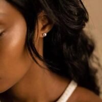 orhangen_titan_blomdahl_7330981154281_15-1233-59_kvinna.jpg صورة مقربة لامرأة ترتدي قرطًا من اللؤلؤ، مما يعكس الأناقة والأسلوب. مثالية لعشاق المجوهرات وعشاق الموضة.