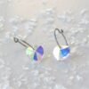 orhangen_titan_blomdahl_7330981158166_15-1255-02_e.jpg Heart-shaped crystal earrings with a shimmering finish, featuring a silver hoop design and colorful reflections, ideal for jewelry collections.