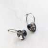 orhangen_titan_blomdahl_7330981158531_15-1255-12_b.jpg Heart-shaped crystal hoop earrings featuring a shiny silver finish and sparkling heart-shaped crystals, perfect for elegant accessories.