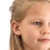 orhangen_nickelfri_plast_blomdahl_15-0199-24_7330981510353.jpg A young girl with light brown hair wearing pink flower stud earrings, showcasing a delicate and charming accessory for children.