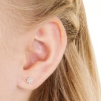 orhangen_nickelfri_plast_blomdahl_7330981150207_15-0114-41_a.jpg Close-up of a woman's ear showcasing elegant diamond flower stud earrings, perfect for adding a touch of sparkle to any outfit.