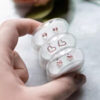 orhangen_nickelfri_plast_blomdahl_7330981150696_7330981510674_7330981510674_15-0121-24_15-01121-24_15-0199-24.jpg A set of pink heart-shaped earrings displayed in a clear case, featuring stud earrings and a heart design, perfect for jewelry collections.