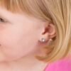 orhangen_nickelfri_plast_blomdahl_7330981510339_15-0199-05.jpg Close-up of a child's ear featuring a blue stud earring, showcasing a cute and stylish accessory for kids.